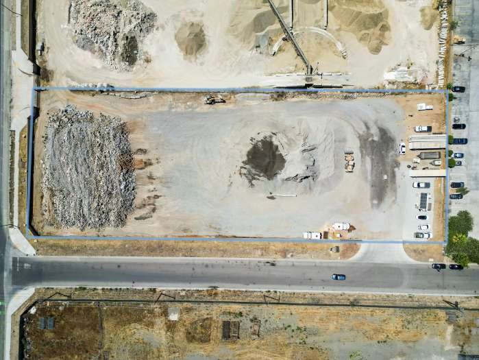 Top-down drone photograph of the yard with the parcel line drawn in blue; Goetz Road on the left edge and Malbert Street along the bottom